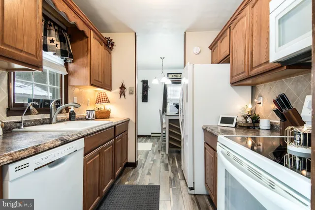 a kitchen with stainless steel appliances granite countertop a refrigerator a stove and a sink