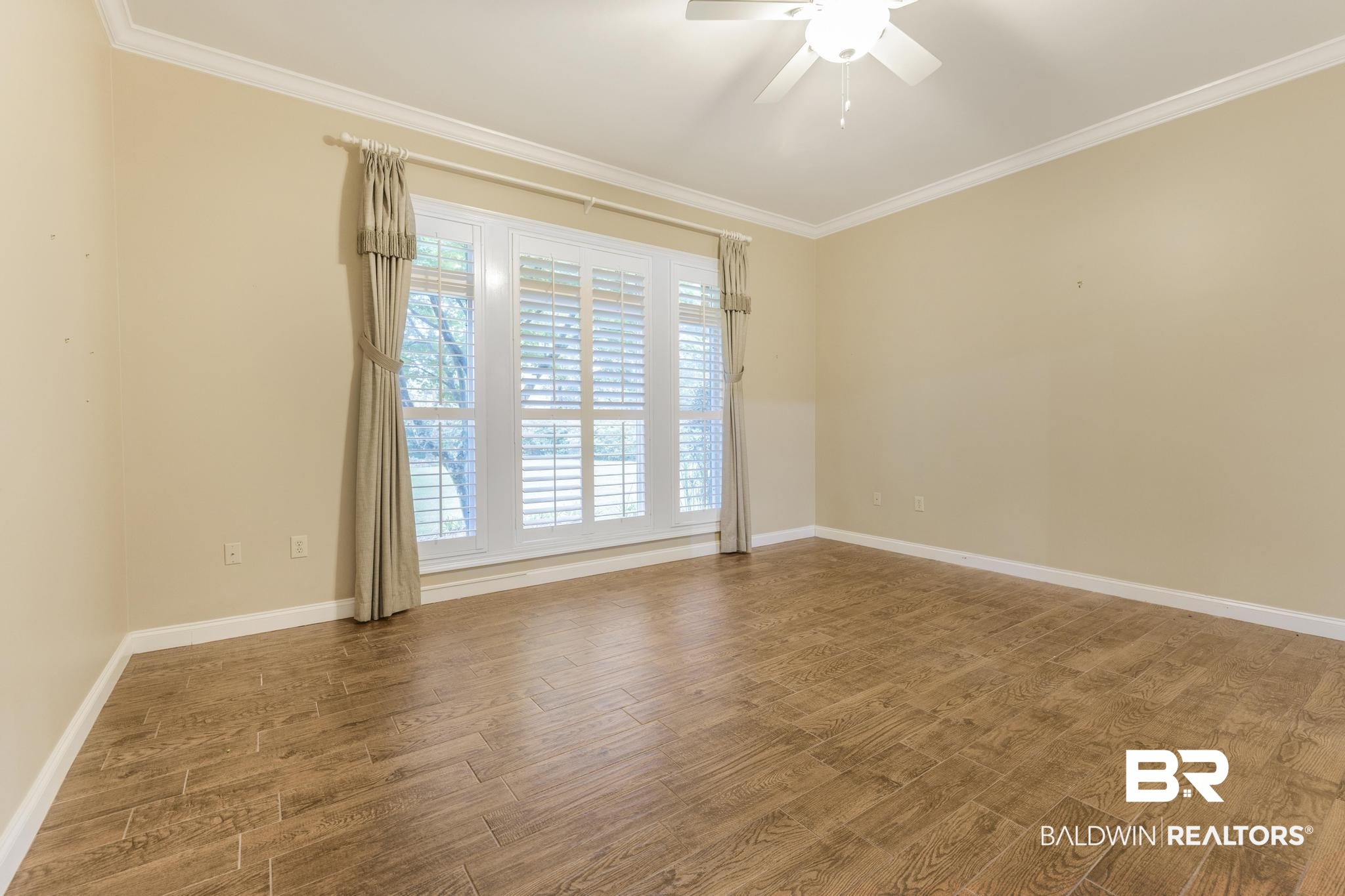 13612 Rue Royal Lane Silverhill, AL 36576 - Photo 19 of 65 Empty room featuring wood finished floors, crown molding, and a ceiling fan
