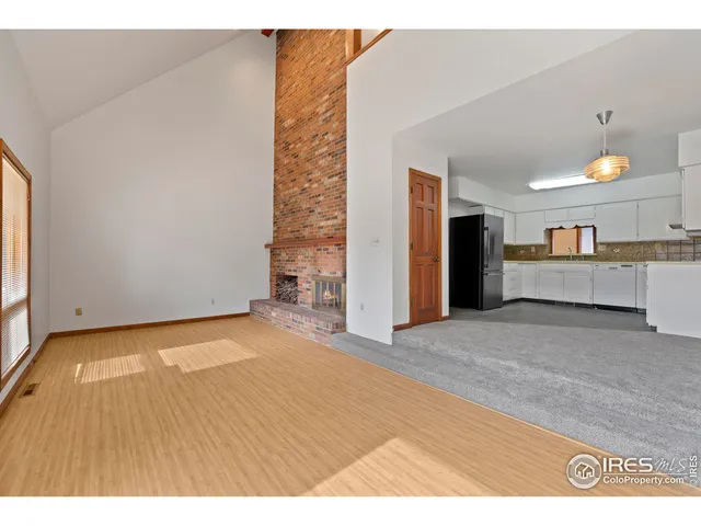 a view of an empty room and kitchen