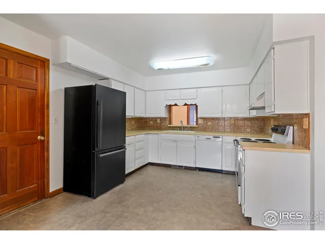 a kitchen with refrigerator and cabinets