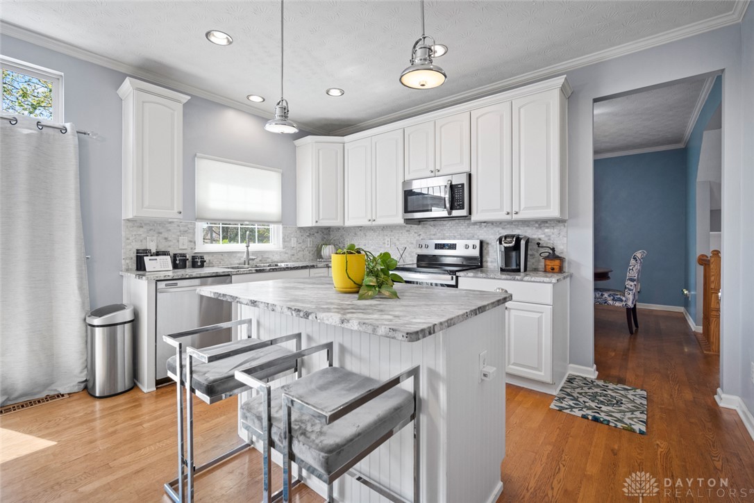 55 Janney Lane Springboro, OH 45066 - Photo 6 of 38 This bright kitchen features white cabinetry and a functional island, perfect for casual dining and entertaining.