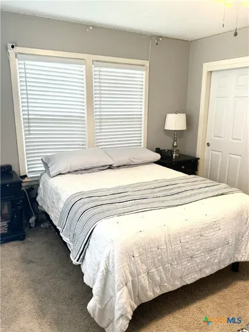 a large bed sitting in a bedroom next to a window