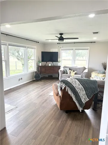 a spacious bedroom with a bed a couch and large window