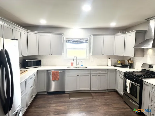 a kitchen with stainless steel appliances a sink stove and refrigerator