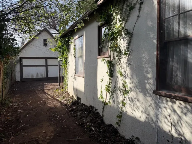 a view of a livingroom with a chandelier curtains and wooden floor