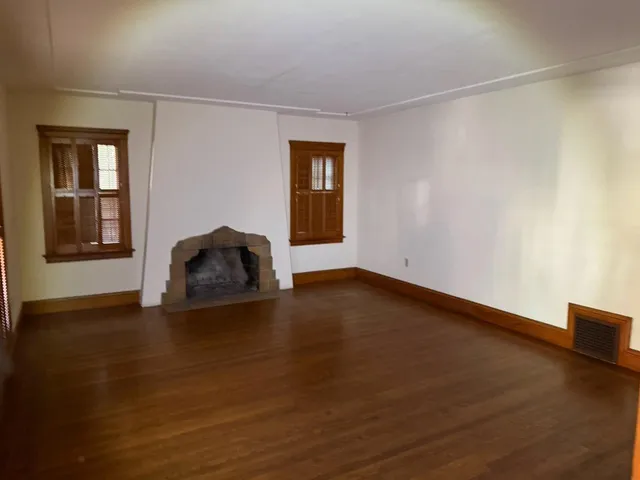 a room with a wooden floor and a window