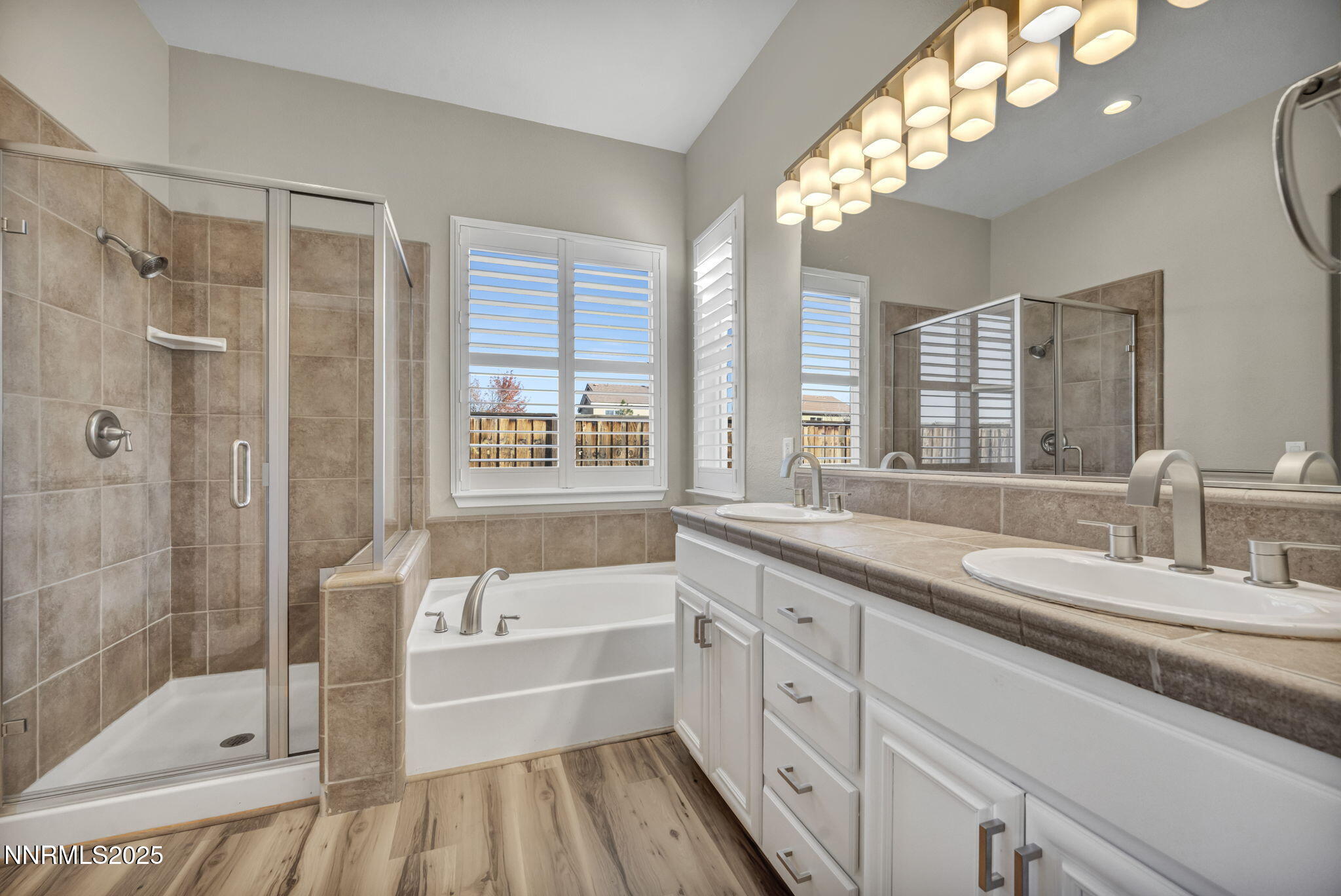 1781 Emerald Bay Drive Reno, NV 89521 - Photo 14 of 42 a bathroom with a granite countertop sink a large mirror a bathtub and next to a window