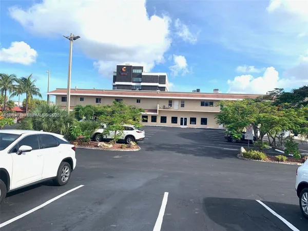 a view of a cars park in front of a building