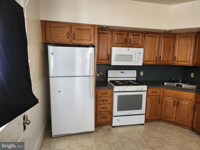 a kitchen with granite countertop a refrigerator and a stove top oven