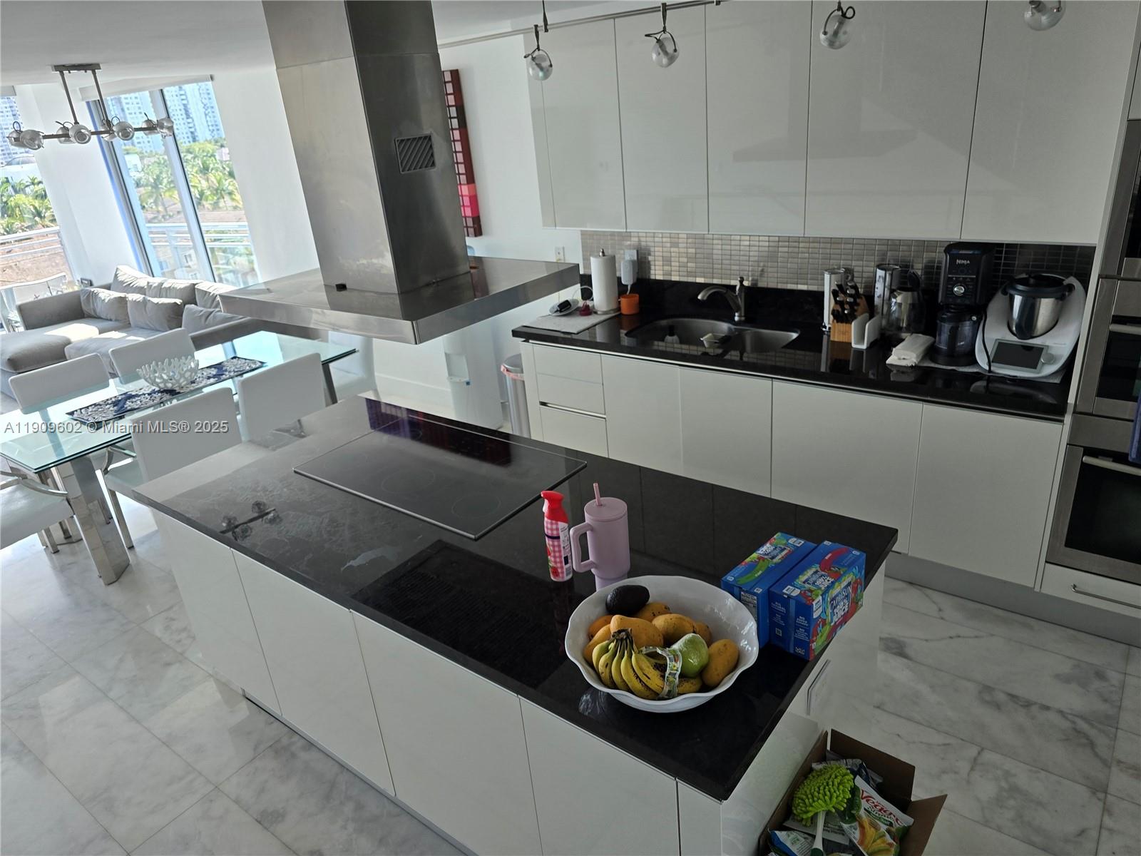 2950 Northeast 188th Street, Unit 501 Aventura, FL 33180 - Photo 22 of 46 a kitchen with a stove a microwave and wooden floor