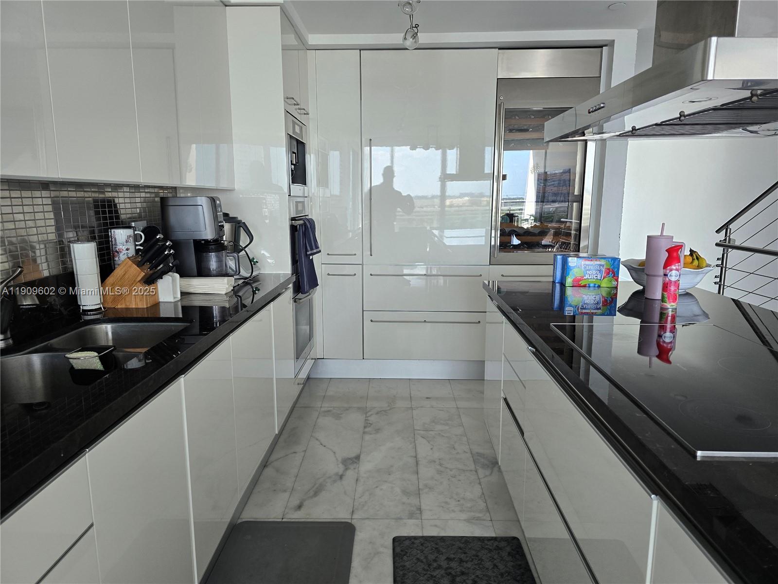 2950 Northeast 188th Street, Unit 501 Aventura, FL 33180 - Photo 23 of 46 a kitchen with stainless steel appliances a sink stove and cabinets