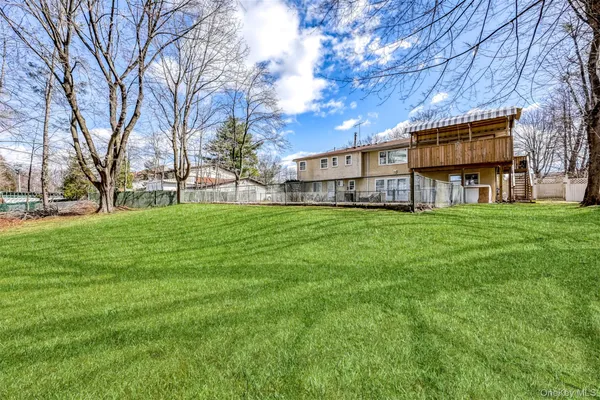 a view of a house with a big yard and large trees