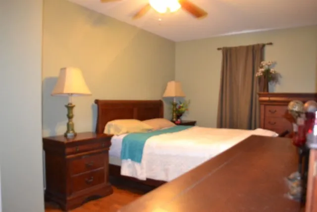 a bedroom with a bed and wooden chair