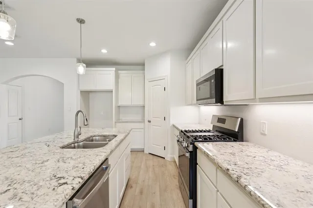 a kitchen with a sink stove top oven and refrigerator