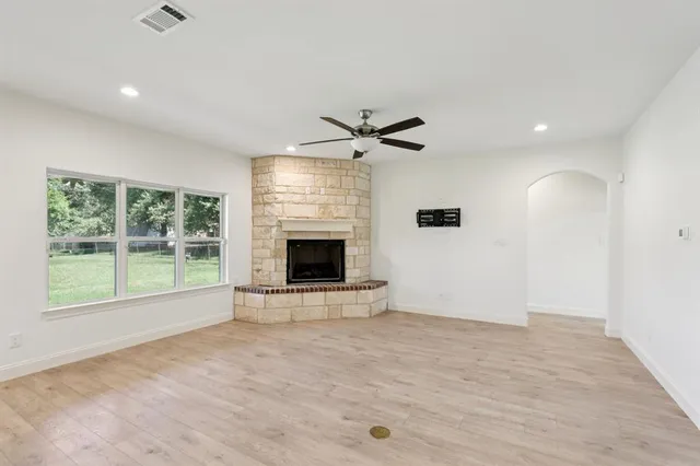 a view of an empty room with a fireplace and a window