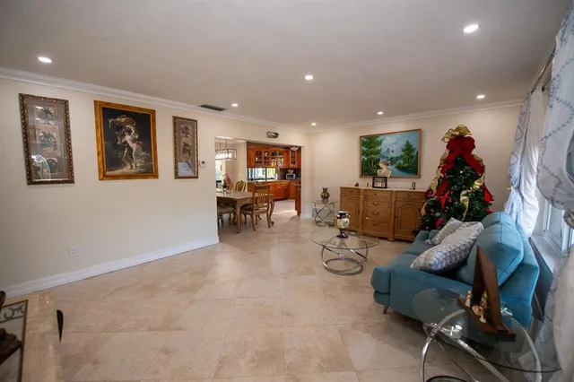 a bedroom with a bed couch chandelier and a window