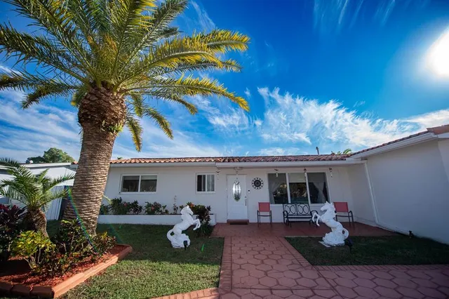 a view of a house with backyard and sitting area