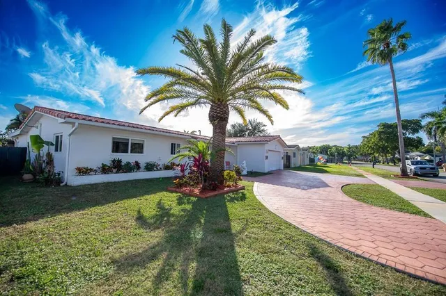 a house view with a sitting space fire pit and outdoor space