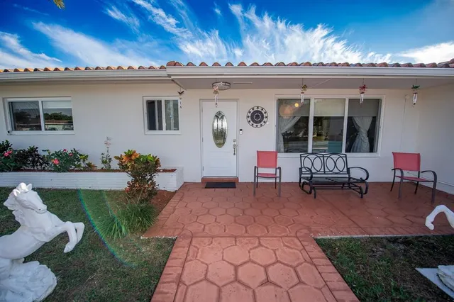 a living room with furniture a flat screen tv and a large window