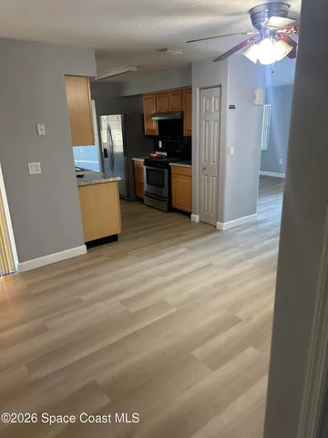 a view of a kitchen with a sink cabinet a microwave and a refrigerator