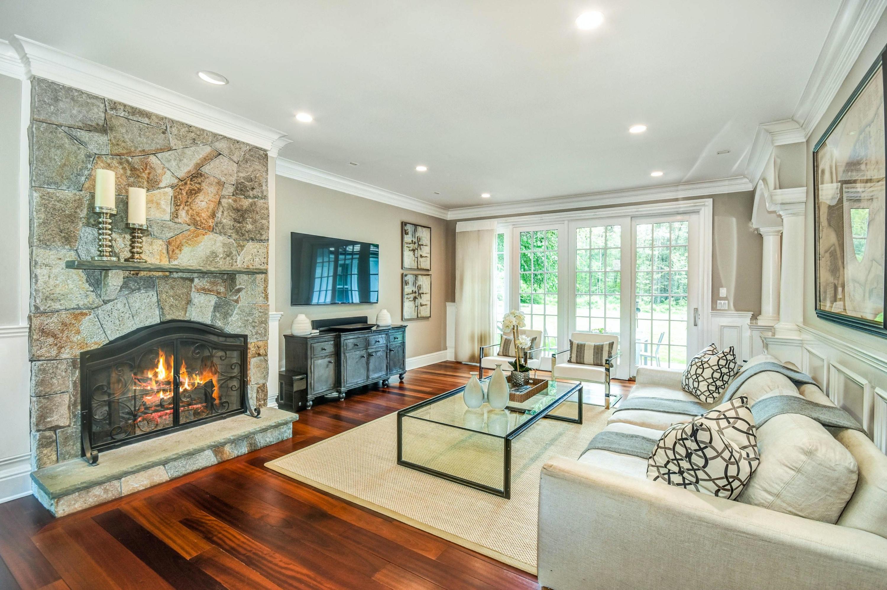 56 Logan Road New Canaan, CT 06840 - Photo 17 of 40 a living room with furniture a fireplace and a floor to ceiling window