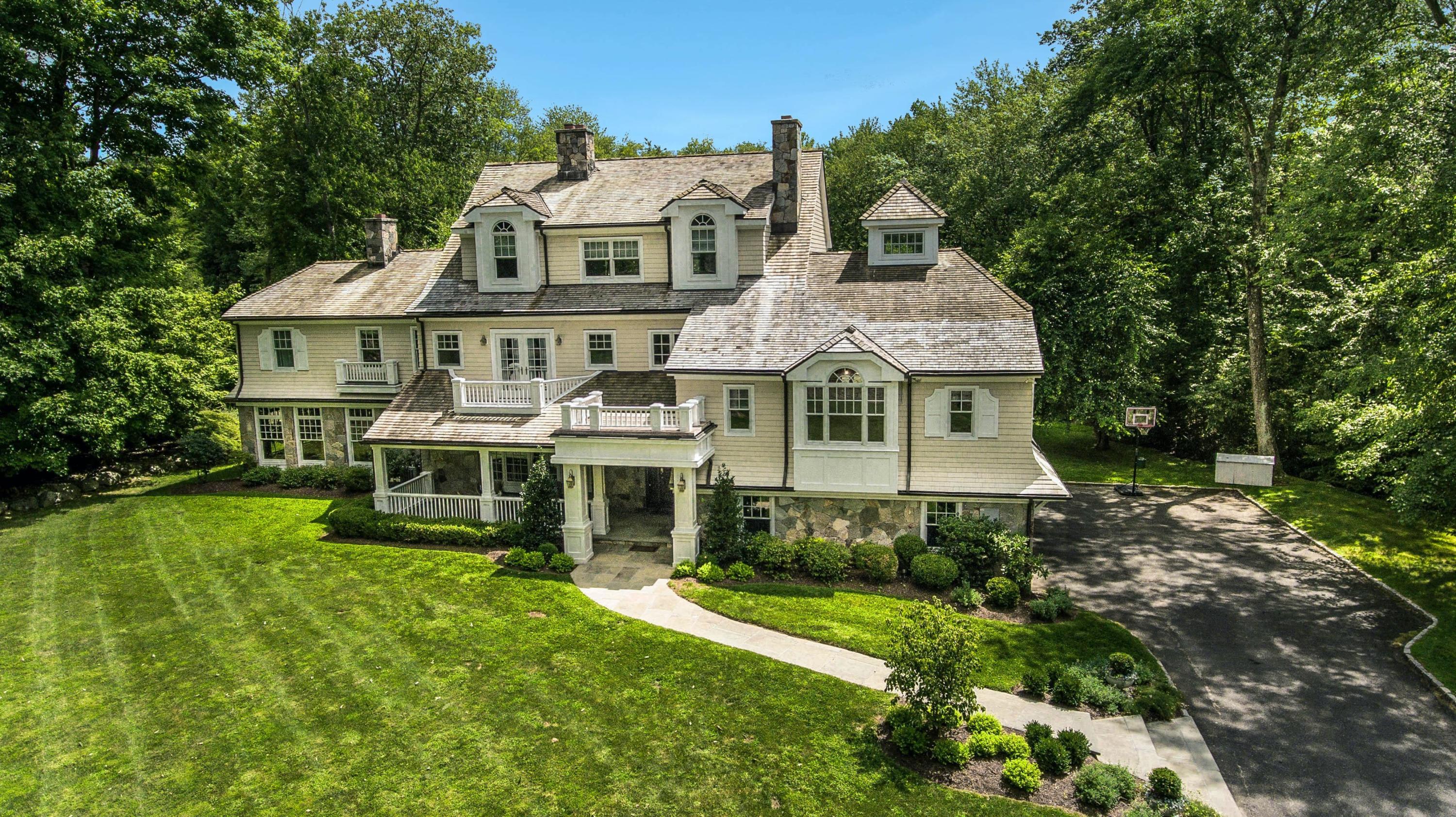 56 Logan Road New Canaan, CT 06840 - Photo 35 of 40 a front view of a house with a yard table and chairs