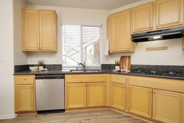 a kitchen with granite countertop wooden cabinets and a sink