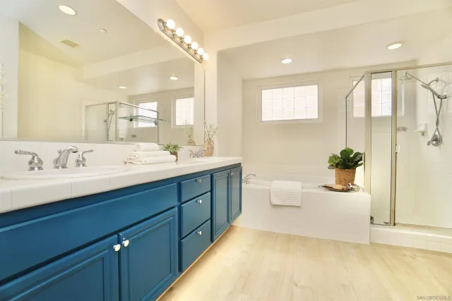 a spacious bathroom with a double vanity sink a large mirror and