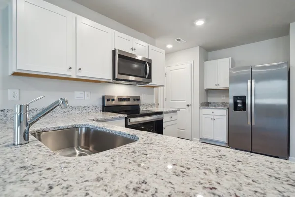 a kitchen with stainless steel appliances granite countertop a sink and a stove top oven