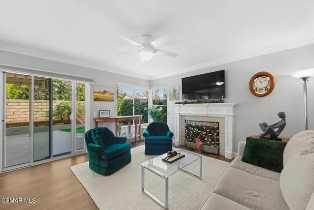 a living room with furniture a fireplace and a floor to ceiling window