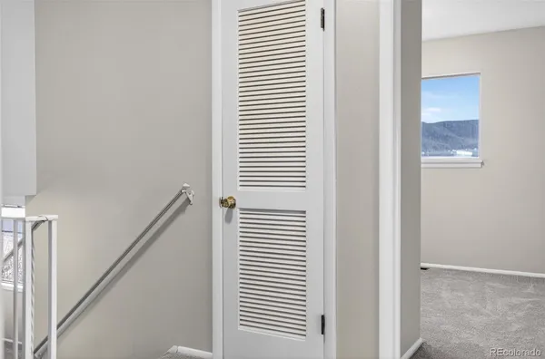 a view of a hallway with a white door and a white door
