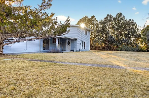 a front view of a house with a tree