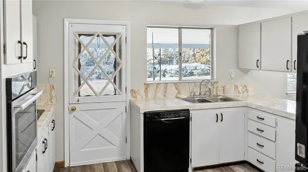a kitchen with granite countertop white cabinets and white appliances