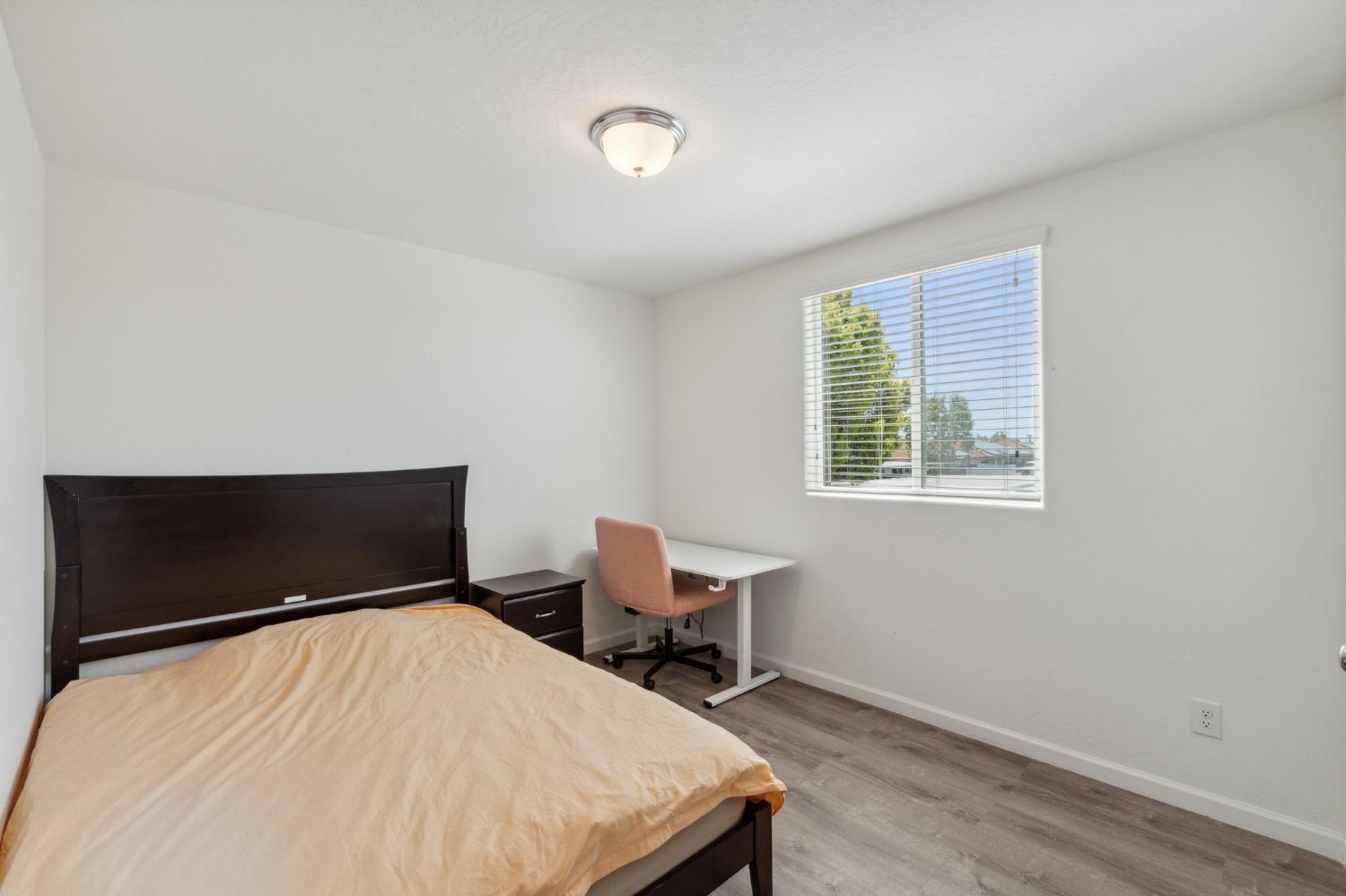 264 Rosebriar Street Madera, CA 93638 - Photo 13 of 28 a bedroom with a bed and chair