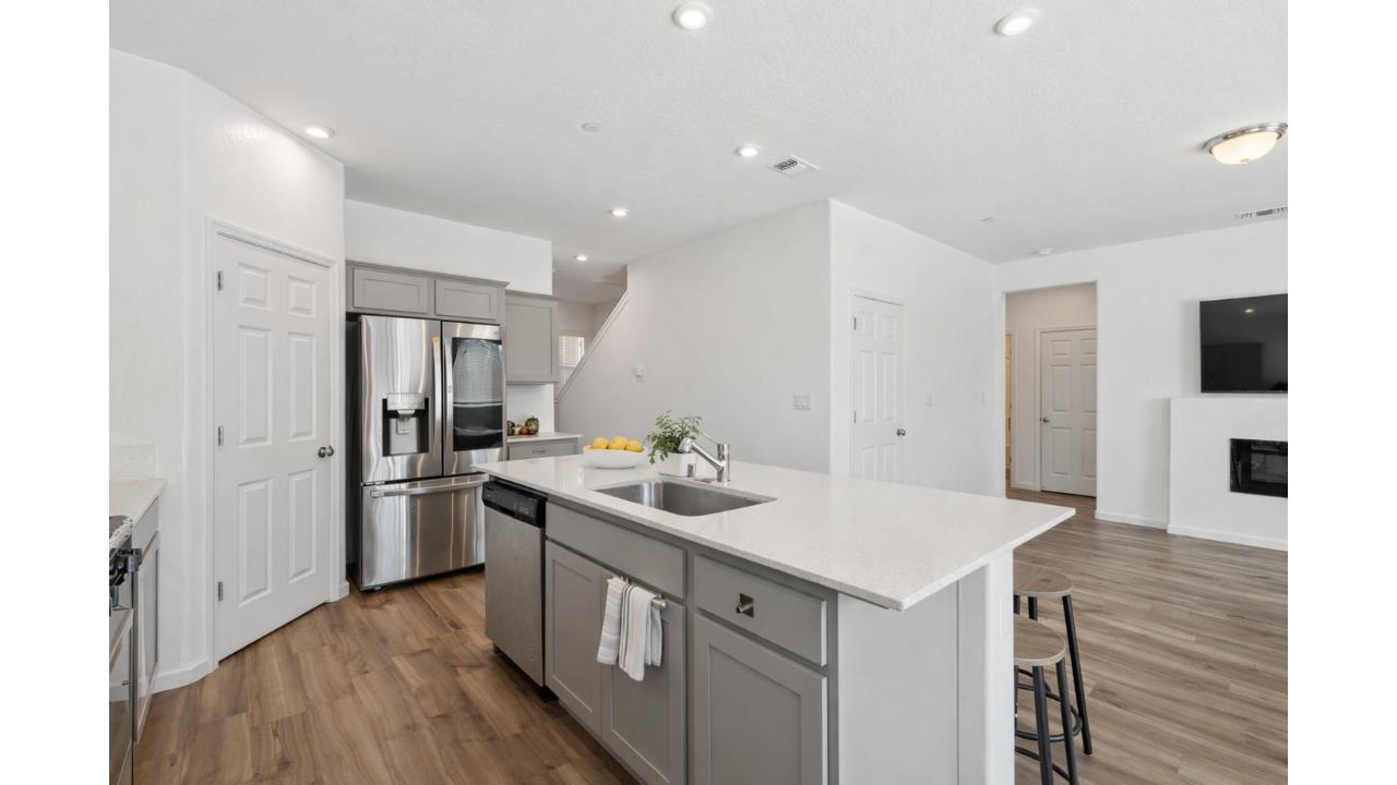 264 Rosebriar Street Madera, CA 93638 - Photo 5 of 28 a kitchen that has a sink a stove and a refrigerator