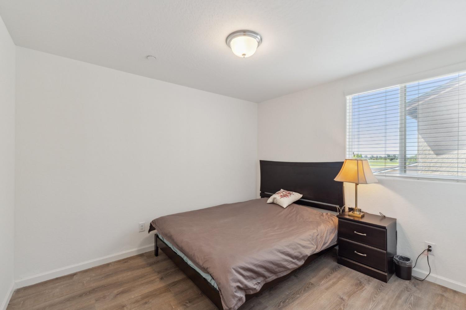 264 Rosebriar Street Madera, CA 93638 - Photo 10 of 28 a bedroom with a bed and wooden floor