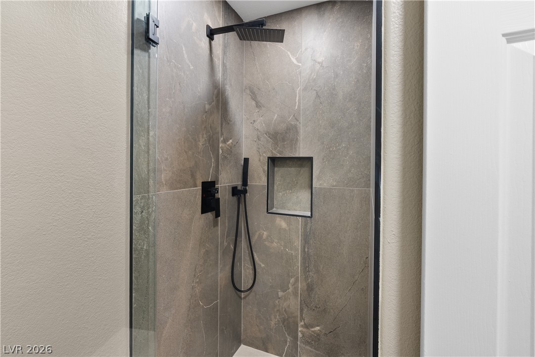 1662 Ravanusa Drive Henderson, NV 89052 - Photo 54 of 74 A sleek, contemporary shower enclosure features a dark-tiled rain shower and convenient in-wall niche.