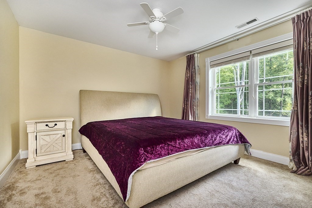 107 Concord Way Amherst, MA 01002 - Photo 22 of 41 a bedroom with a bed and a chandelier fan