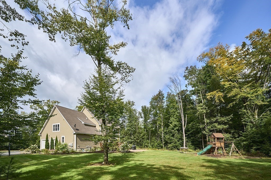 107 Concord Way Amherst, MA 01002 - Photo 4 of 41 a view of a white house with a big yard and potted plants