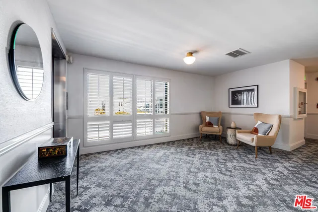 a living room with furniture and a floor to ceiling window