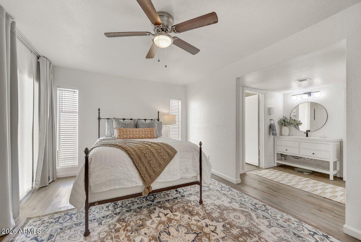 1301 West Rio Salado Parkway, Unit 51 Mesa, AZ 85201 - Photo 12 of 30 a bedroom with a bed a chandelier and dresser