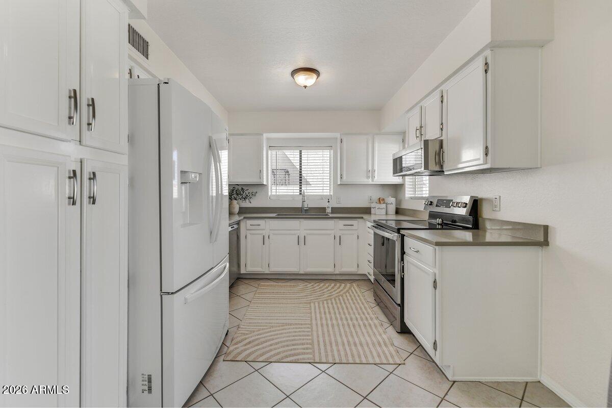 1301 West Rio Salado Parkway, Unit 51 Mesa, AZ 85201 - Photo 7 of 30 a kitchen with white cabinets and white appliances