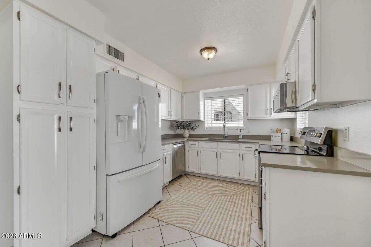 1301 West Rio Salado Parkway, Unit 51 Mesa, AZ 85201 - Photo 8 of 30 a kitchen with white cabinets and white appliances