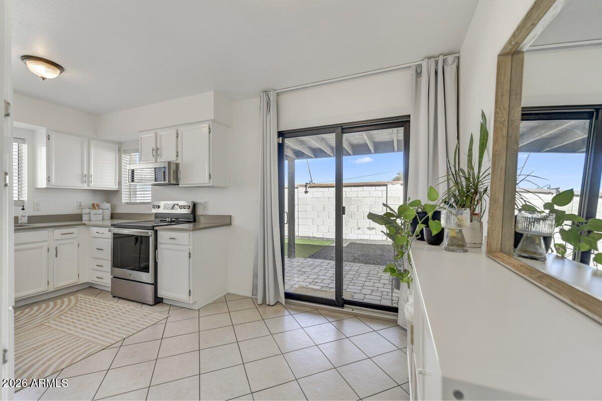 1301 West Rio Salado Parkway, Unit 51 Mesa, AZ 85201 - Photo 10 of 30 a kitchen with a refrigerator a stove top oven and white cabinets