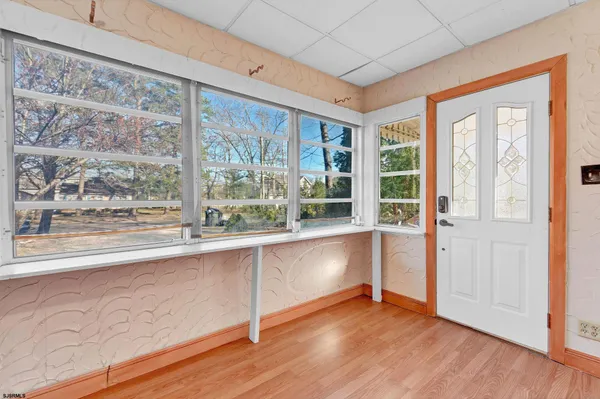 a view of a large window with wooden floor and garden view