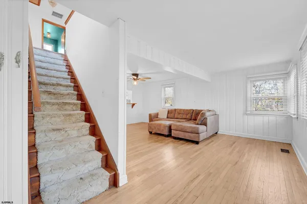 a living room with furniture and wooden floor