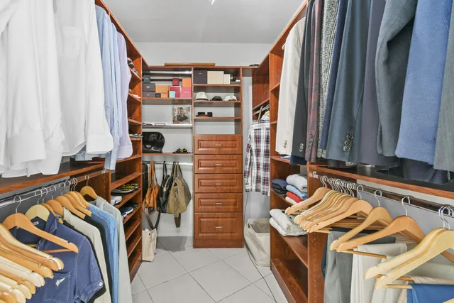 a view of walk in closet with clothes and shoes