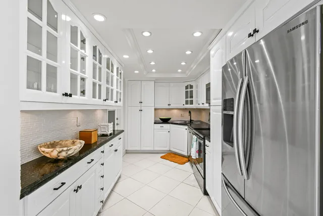 a kitchen with stainless steel appliances granite countertop a refrigerator and a stove