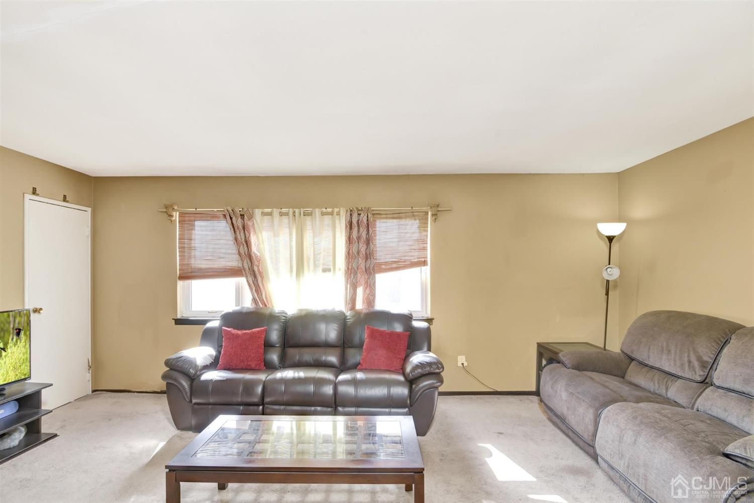199 Evergreen Road, Unit 4B Edison, NJ 08837 - Photo 7 of 28 a living room with furniture and a large window