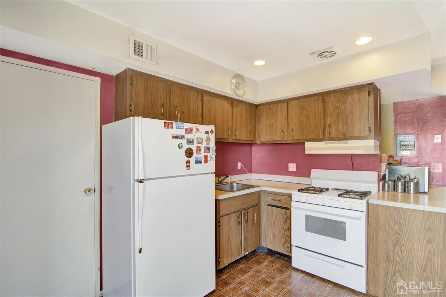 199 Evergreen Road, Unit 4B Edison, NJ 08837 - Photo 9 of 28 a kitchen with a white stove top oven and refrigerator